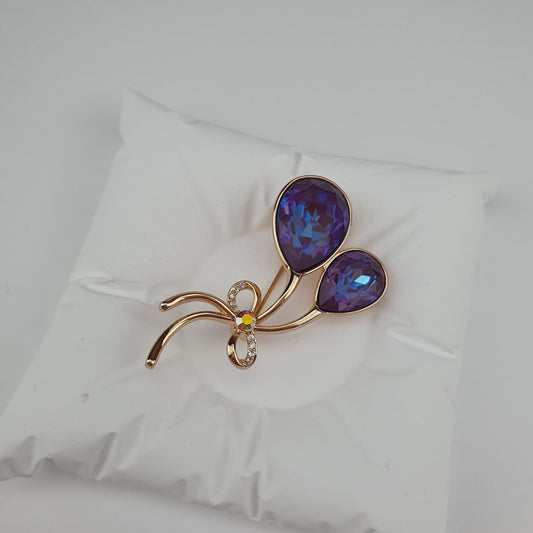 Eleganta apzeltīta piespraude ar violetiem Swarovski akmeņiem