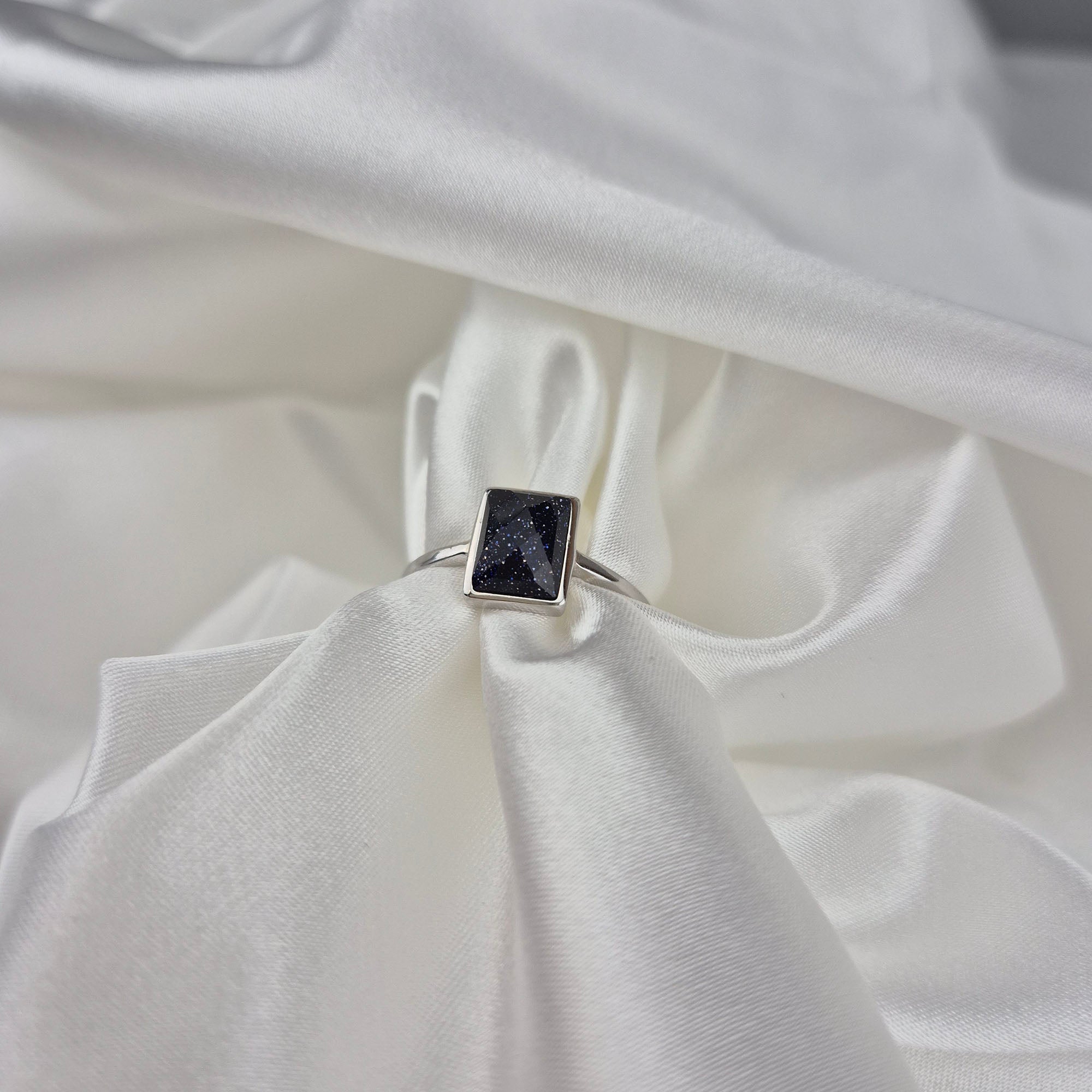 Antialerģisks sudraba gredzens ar spīdīgu zilu akmeni un elegantu, minimālistisku dizainu.